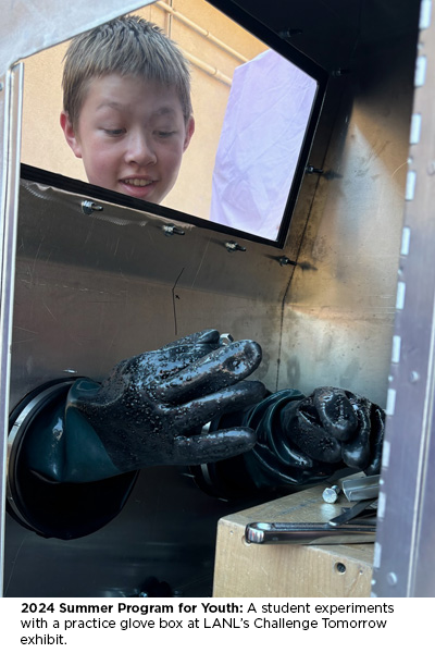 2024 Summer Program for Youth: A student experiments with a practice glove box at LANL’s Challenge Tomorrow exhibit.