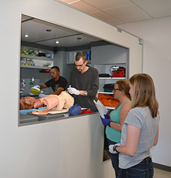 EMS students next to simulator